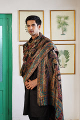 Man draped in jewel-tone paisley woven shawl for wedding