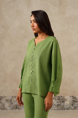 Close-up of button-down front on green linen shirt