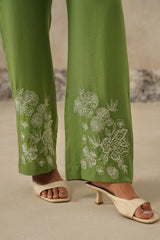 Detail of embroidered floral pattern on green linen pants