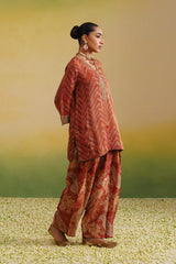 side view wearing rust printed farshi salwar set with embroidered neckline and dupatta