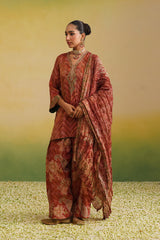 Full view of Woman wearing rust printed farshi salwar set with embroidered neckline and dupatta,paisley print, chevron print, embroidery neckline, green contrast