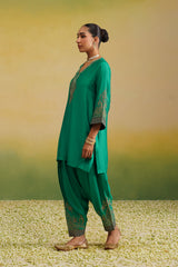 Woman in emerald green embroidered suit set, side profile