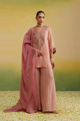 Woman wearing blush pink hand embroidered sharara set with contrast pink dupatta