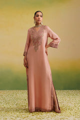 Woman wearing blush pink hand embroidered kaftan dress with front slit