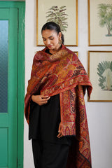 Man draped in deep red woven shawl for wedding function