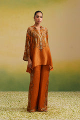 Woman wearing rust paisley printed asymmetric coord set with wide-leg pants