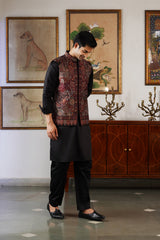 Man wearing maroon kani paisley Nehru jacket over black kurta and pant